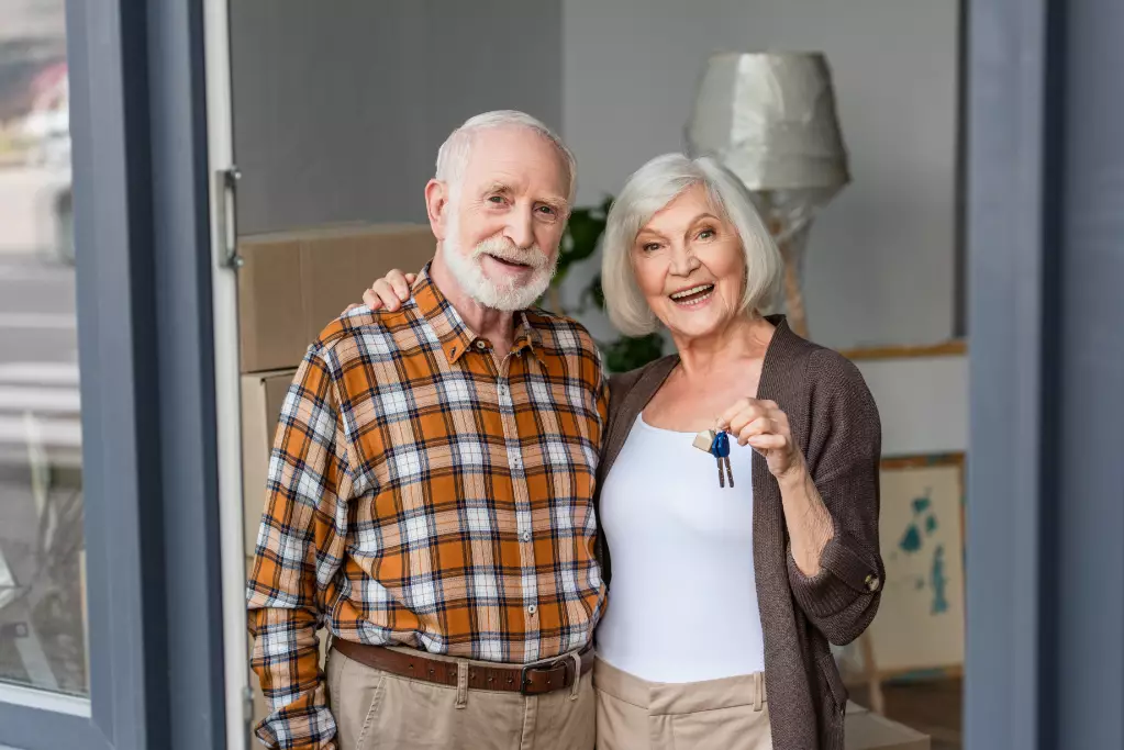 Laughing senior woman holding keys